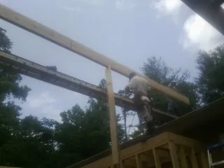 Carpenter setting a ridge beam over a new addition frame — Ice Dam Removal by Roofing Brothers in Forks