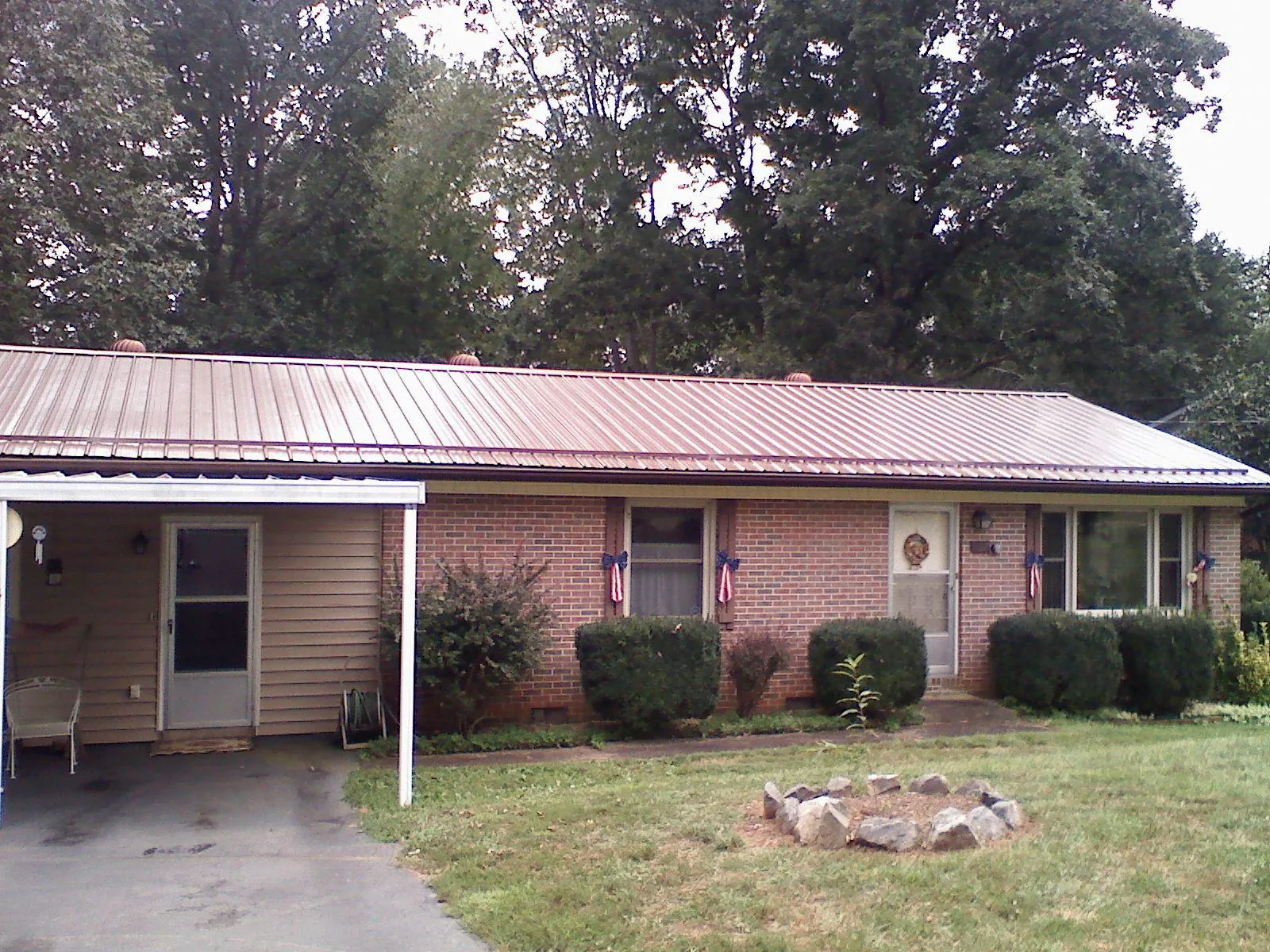 Bronze metal roof and carport on a brick ranch home — Roof Repair work by our crew in Forks